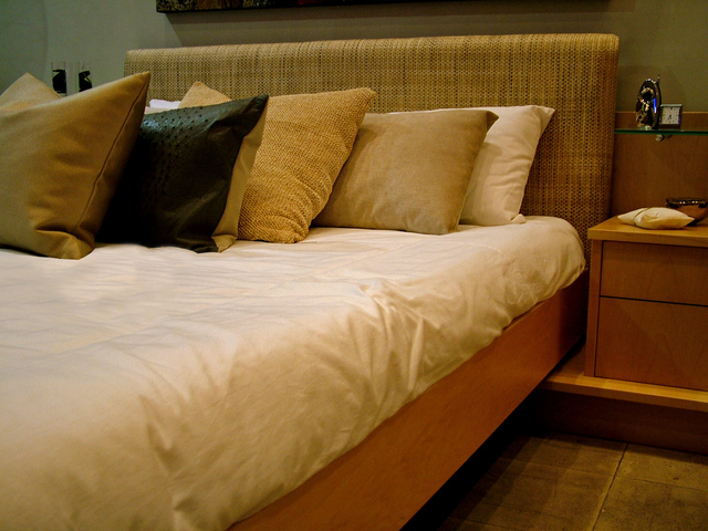 postel plná polštářů